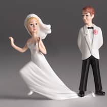 Die drei häufigsten Irrtümer zur Ehe Ein Ehepaar als Zuckergussfiguren. Die Braut versucht zu fliehen, doch der Bräutigam steht auf ihrem Hochzeitskleid und hindert sie daran.