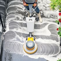 Über die Nebenkosten geschuldet? Ein Hauswart reinigt die Bodenplatten mit einer Putzmaschine vor dem Hauseingang.