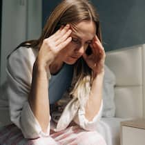 Wann eine Hormontherapie sinnvoll ist – und wann nicht Eine Frau mittleren Alters sitzt zu Hause und h‰lt sich die H‰nde an die Schl‰fen. Kopfschmerzen, Frauengesundheit, Hormonspiegel. Finanzkrise. A middle-aged woman sitting at home holds her hands on her temples. Headache, women s health, hormon…
