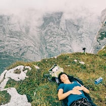 Mit diesen 6 Psycho-Tricks erholen Sie sich sicher in den Ferien Frau liegt entspannt auf einer Alp - Oft ist das Herunterfahren gar nicht so einfach. Denn für wahre Erholung braucht es mehr als Berge oder Strand. Die Psychologie hat sechs zentrale Punkte entschlüsselt, die Ferien erholsam machen