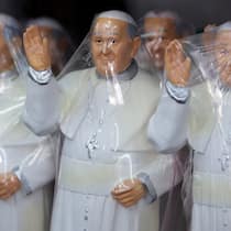 Sie machen Geld mit Austritten aus der Kirche Bild von verpackten Souvenir-Papstfiguren.