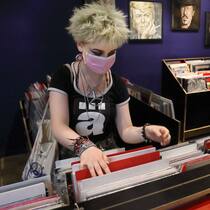 Wer Schallplatten will, muss Monate warten Junge Frau stöbert in Plattenladen