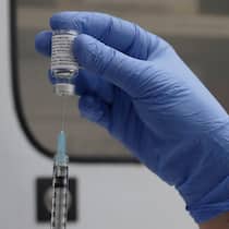 So funktioniert der Corona-Impfstoff von Novavax Mann zieht Spritze mit einer Dosis des Impfstoffs von Novavax auf