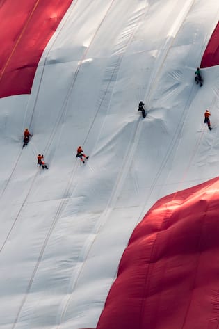 Hoehenarbeiter haengen eine 80x80 Meter grosse Schweizerfahne an einer Felswand unterhalb des Saentis auf, anlaesslich des Nationalfeiertags, am Dienstag, 31. Juli 2018, auf der Schwaegalp. (KEYSTONE/Benjamin Manser)