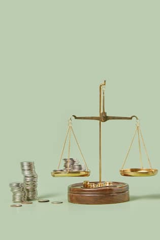Münzen auf einer Waage - symbolisiert Geld und Gerechtigkeit in der Justiz