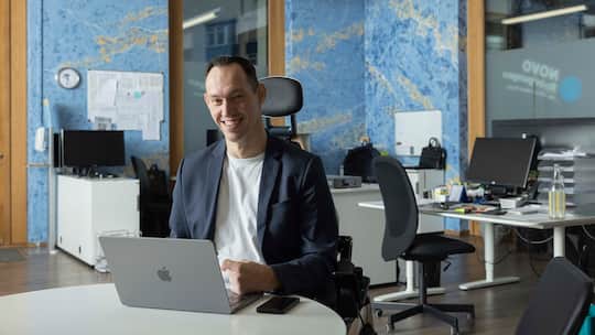 Islam Alijaj sitzt hinter dem Laptop.