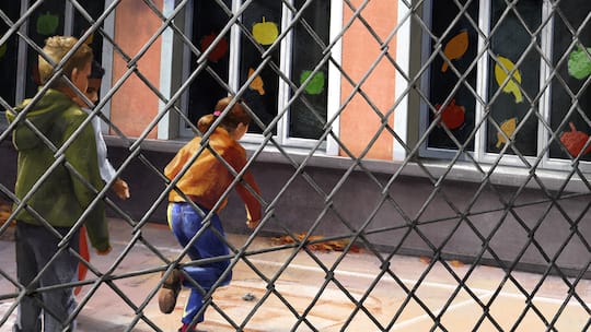 Kinder spielen auf dem Schulhof, im Vordergrund ein Maschendrahtzaun. Ein Bub wird zweimal suspendiert. Der Grund sei sein Verhalten. Darf ein Schulleiter so weit gehen?