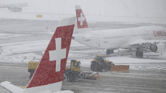 Fahrzeuge befreien den Flughafen Zürich von den verschneiten Pisten. Diese Rechte haben Sie, wenn Ihr Flug wegen dem Winterchaos ausfällt.