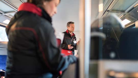 Angestellte der SBB kontrollieren in einem Zug das Billett der Passagiere. In der Schweiz hat das Schwarzfahren zugenommen.