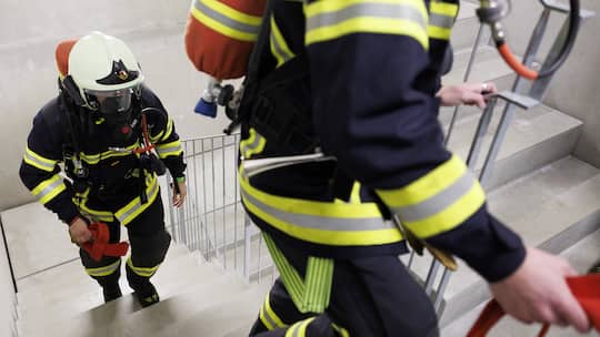 Mitglieder der freiwilligen Feuerwehr steigen eine Treppe hinauf