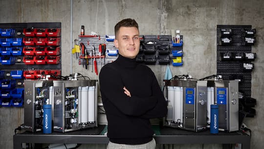 Evodrop-Gründer Fabio Hüther steht vor seinen Geräten