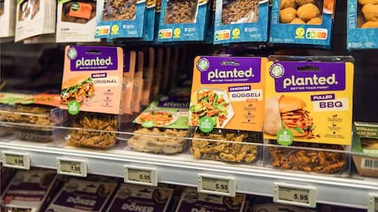 Verschiedene Fleischersatz-Produkte hängen im Kühlregal eines Coop Supermarkts