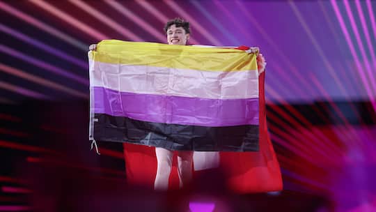 Nemo hält eine Non-Binary-Fahne am Finale des Eurovision Song Contest