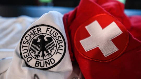 Schweizer und deutsches Fussballtrikot in Nahaufnahme nebeneinander.