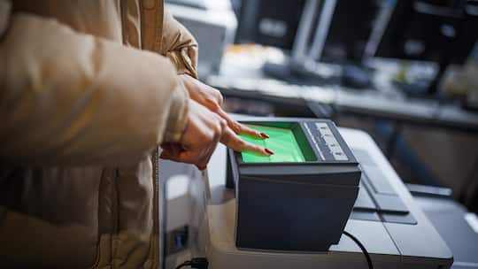 Eine Ukrainerin legt ihre Finger zur auf ein Scangerät zur Aufnahme der Fingerabdrücke bei der Registrierung für Asylantrag.