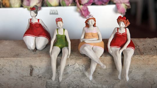 Tonfiguren von fülligen Frauen.