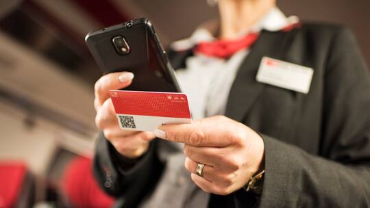 A train conductor of the Swiss Federal Railways checks a passenger's Swiss Pass on a train travelling from Zurich to Lucerne, Switzerland, on March 20, 2017. (KEYSTONE/Christian Beutler)