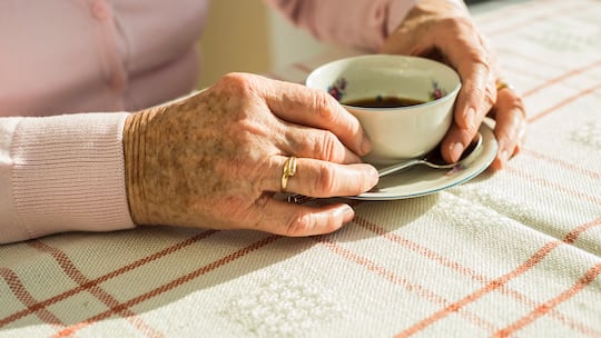 Ältere Dame (Hände) mit einer Tasse Kaffee
