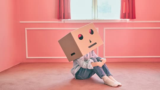 Ein Kind mit einer Kartonschachtel über dem Kopf