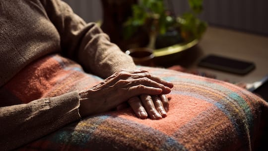 Frauenhände auf dem Schoss - Trotz Sieg vor Bundesgericht muss eine Rentnerin weiter um ihr Geld kämpfen. Die Gemeinde Küsnacht ZH verzögert die Auszahlung – bis der Beobachter interveniert