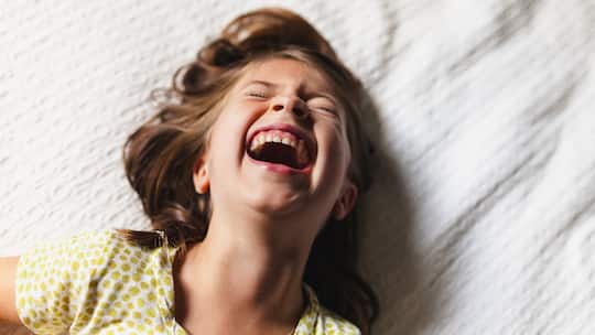Fünfjähriges Kind lacht aus vollem Hals