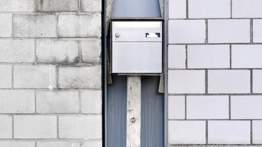 Briefkasten an einer Mauer - Wer die Steuern optimieren will, wandert in steuergünstige Kantone ab. Ein neues Urteil des Bundesgerichts zeigt nun: Wer dabei trickst, zahlt am Ende doppelt. Die Chronik eines Debakels