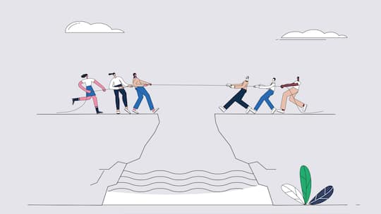 A group of men and women are competing in a tug of war on a cliff.