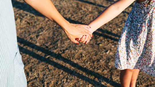 Mutter und Tochter Hand in Hand