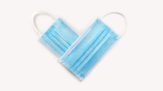 Zwei Hygienemasken bilden ein Herz. Sars-CoV-2, das Covid-19-Virus, greift auch das Herz an und führt zu Herzschwäche, Infarkten und Rhythmusstörungen.