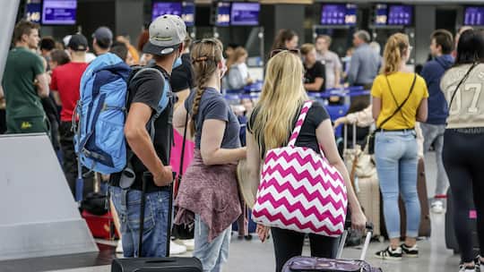 27.07.2022, Duesseldorf, Nordrhein-Westfalen, Deutschland - Flughafen Duesseldorf, Urlauber stehen mit Koffern am Check-in Schalter am Tag des Warnstreiks vom Lufthansa Bodenpersonal. 00X220722D126CARO . (KEYSTONE/CARO/Rupert Oberhaeuser)