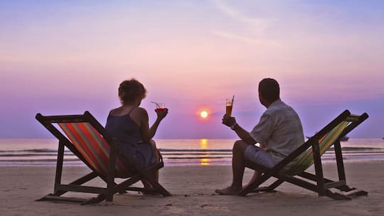 Ein Paar am Meer bei Sonnenuntergang - Wie man sich auf eine Frühpensionierung vorbereitet.