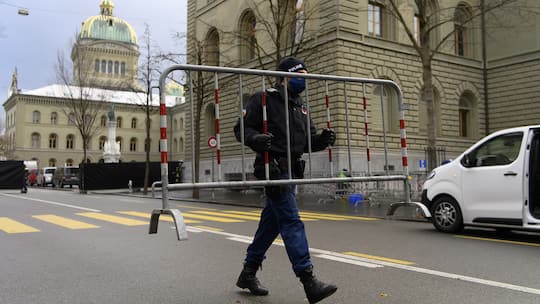 Polizist trägt Abschrankung – im Hintergrund das Bundeshaus in Bern (28. November 2021)