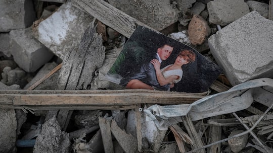 Foto eines Paares in den Trümmern nach einem russischen Raketenangriff, im ukrainischenDorf Rivne