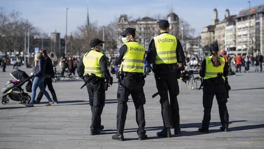 Vier mit einer gelben Weste bekleidete Polizistinnen und Polizisten beaufsichtigen den Sechseläutenplatz in Zürich. Was die Polizei darf und welche Rechte Bürgerinnen und Bürger haben, die von ihr kontrolliert werden, ist rechtlich festgelegt.