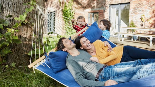 Eltern in Hängematte, Kinder schaukeln sie - Der Trend, Kinder vom Sofa aus zu bespassen, wirkt kurios, hat aber einen ernsten Kern: Eltern sind am Limit. Warum «Spielen im Liegen» legitime Notwehr ist