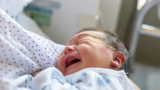 Ein Neugeborenes in einem Spital weint