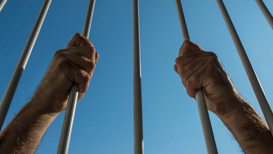 Mann greift an Gitterstäbe