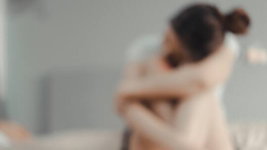 Frau sitzt traurig auf dem Bett (Symbolbild)