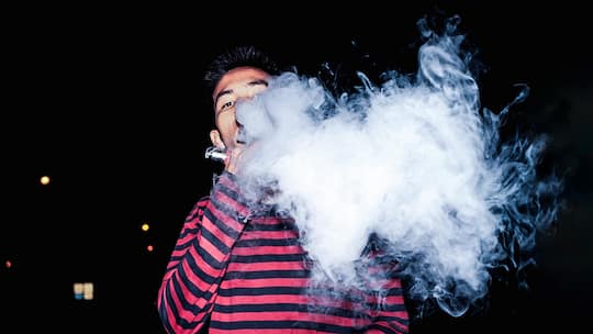 Jugendlicher dampft mit E-Zigarette