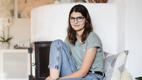 Carina Bürgisser aus Ägeri sitzt zu Hause vor dem Cheminée. Ihr wurde ein Spenderherz transplantiert