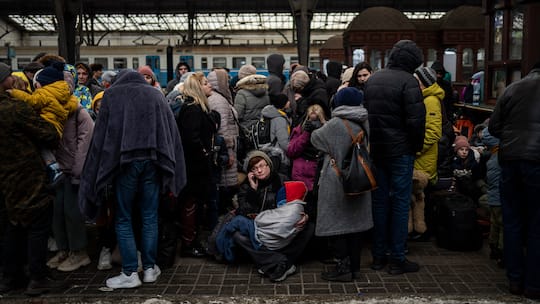 Dutzende Menschen warten auf einem Perron am Bahnhof Lwiw