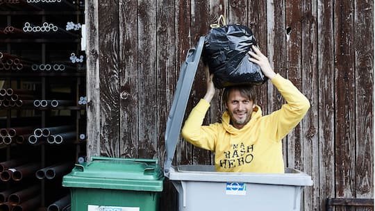 Roman Peter sitzt zum Scherz in einem Müllcontainer. Er befreit die Umwelt von Abfall und hat die Organisation Trash Hero World gegründet.