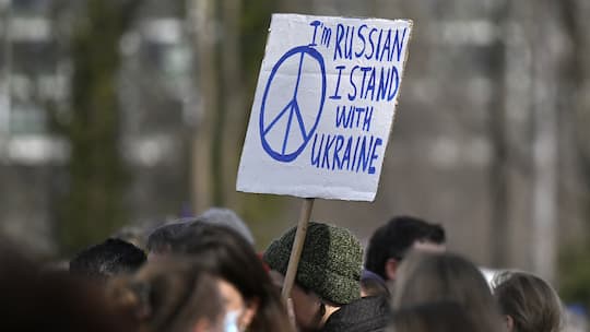 Mann hält an Friedenskundgebung in Bern ein Schild «I'm Russian, I stand with Ukraine» hoch