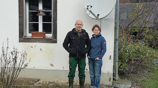 Andrea und Roman Nussbaumer vor ihren Haus mit Satellitenschüssel