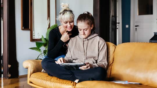 Unterstützung für Teenager in der Pubertät: Tante und Nichte zusammen auf dem Sofa