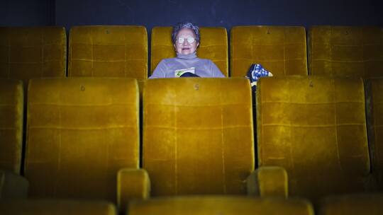 Eine Zuschauerin verfolgt einen Film im Kino Kosmos.