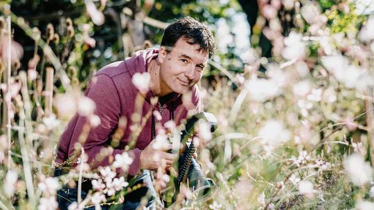 Portrait Simon Köchlin und beim fotografieren von Schwebefliegen in seinem wilden Garten