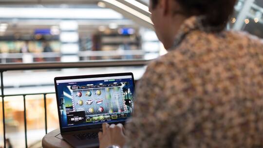 Ein Mann spielt ein Online Casino Spiel auf seinem Computer.