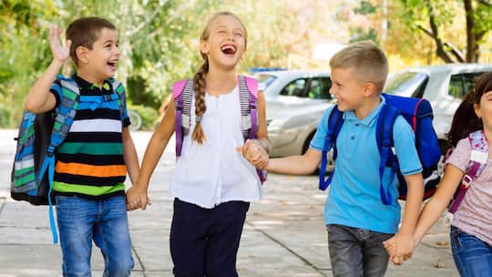 Lachende Erstklässler auf dem Schulweg - Der Schulstart fällt vielen Kindern schwer. Diese sieben Tricks helfen Ihnen und Ihrem Kind, die erste Zeit leichter zu meistern