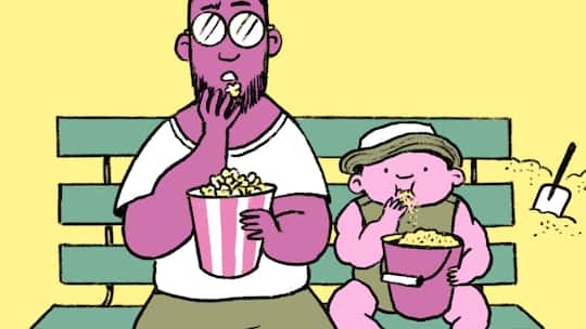 Papa und Kind essen Popcorn